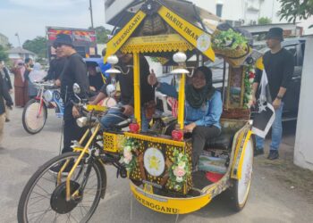 SARAYA Arbi menaiki sebuah beca pada majlis perasmian program Jerayawara Seni Dwimusim Kuala Terengganu di Kuala Terengganu, hari ini.