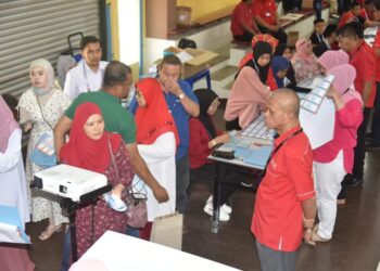 NIK Dir Nik Wan Ku (kanan) memerhati proses pemilihan UMNO Bahagian Marang di Marang, hari ini.