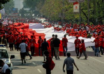 PENYOKONG Jokowi membawa bendera gergasi Indonesia sempena pentadbiran beliau memasuki penggal kedua di Jakarta, 2019.-AFP