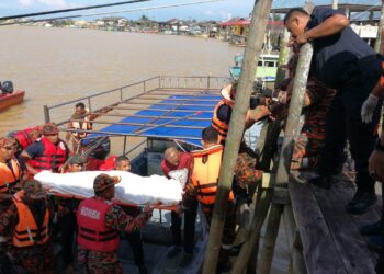 PASUKAN penyelamat mengusung mayat lelaki yang ditemukan lemas di Sungai Paka, Dungun, petang ini. - UTUSAN/NIK NUR IZZATUL HAZWANI NIK ADNAN