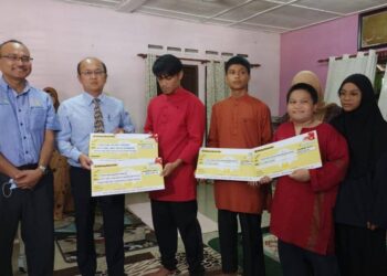 NGWE Hee Sem (dua dari kiri) menyampaikan replika cek faedah pengurusan mayat kepada waris pasangan OKU yang terkorban akibat kemalangan di Jalan Pantai Serkam, Jasin, Melaka. - UTUSAN/DIYANATUL ATIQAH ZAKARYA