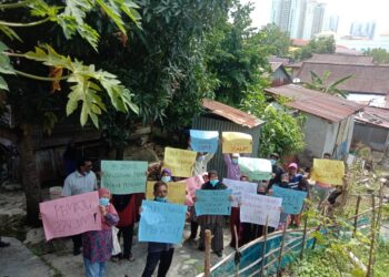 PENDUDUK Kampung Jalan Tanjung Tokong, George Town, Pulau Pinang berkumpul membantah cadangan pembinaan rumah bertingkat berdekatan kediaman mereka, semalam. – Utusan/NOOR HASLIZA NUSI