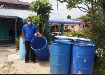 ALIAS Hanafi menunjukkan tong kosong di hadapan rumahnya berikutan gangguan bekalan air di Kampung Sungai Gelam, Merbok, Sungai Petani hari ini. - UTUSAN/OTHMAN YAHAYA