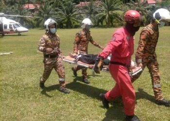 ANGGOTA bomba dan penyelamat membantu pegawai perubatan mengangkat Bah Hong Tingkah ke atas ambulans untuk dibawa ke Hospital Lipis selepas penerbangan ihsan bomba mendarat di padang Sekolah Kebangsaan Wan Ibrahim di Lipis, Pahang. - FOTO/IHSAN JBPM PAHANG