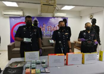 MOHD. Haki Hasbullah (tengah) menunjukkan wang tunai dan dadah yang dirampas dalam sidang akhbar di IPD Kemaman di Kemaman, Terengganu, hari ini. - NIK NUR IZZATUL HAZWANI NIK ADNAN