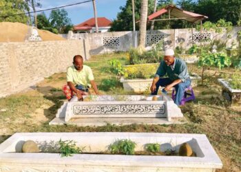 YUSOFF Abdul Rahman (belakang) bersama Azharuddine Mat Soh menggali kubur di Tanah Perkuburan Islam Kampung Semut Api, Kota Bharu. - UTUSAN/FOTO ROSLIZA MOHAMED