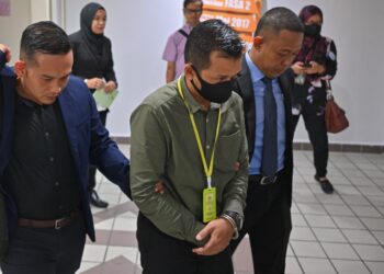 ABOL As Mohd. Jamil (tengah) yang mengaku tidak bersalah atas tuduhan meminta dan menerima suapan RM35,000 dibawa keluar dari Mahkamah Sesyen, Kuala Terengganu, hari ini. - UTUSAN/PUQTRA HAIRRY ROSLI