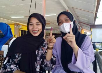 NUR Asma Alias (kanan) ditemani rakan baiknya, Zakiah Zulkifli menunjukkan jari masing-masing yang dicelup dakwat menandakan selesai mengundi di SK Rantau Panjang, Kota Kuala Muda di Sungai Petani. -UTUSAN/OTHMAN YAHAYA