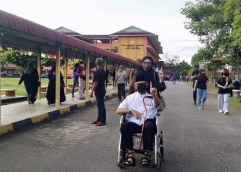 ARIFFIN Osman ditemani isteri, Faizah Baharum menunjukkan jari berdakwat selepas menjadi individu pertama mengundi di SMK Taman Ria Jaya, Sungai Petani. -UTUSAN/OTHMAN YAHAYA
