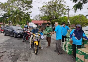 PARA peniaga pasar malam yang terjejas akibat PKP menerima sumbangan disampaikan Nik Faiz Nik Amin secara pandu lalu di Taman Kemahkotaan, Tumpat, Kelantan, semalam. - FOTO/ROSALWANI CHE SOH