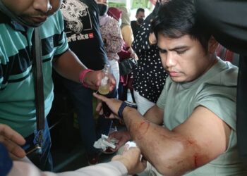 BEBERAPA penumpang membantu memberi rawatan awal kepada Ahmad Fadzil yang cedera terkena serpihan kaca cermin tingkap feri yang pecah di Langkawi, Kedah, petang ini. - UTUSAN/ZAID MOHD. NOOR