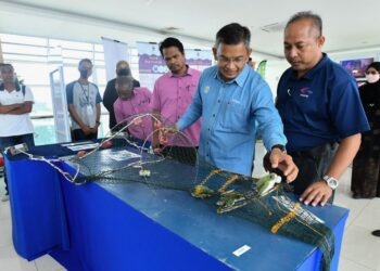 AZMAN Ibrahim (dua, dari kanan) melihat pameran dalam Program Kesedaran Cakna Penyu di galeri jambatan angkat di Kuala Terengganu, semalam. - PUQTRA HAIRRY ROSLI
