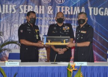 MIOR Faridalathrash Wahid (tengah) menyaksikan penyerahan tongkat kuasa antara Sulizmie Affendy Sulaiman (kiri) kepada Koo Tai Chew pada majlis serah terima tugas Ketua Polis Daerah Muallim di IPD Muallim semalam. - UTUSAN/ZULFACHRI ZULKIFLI