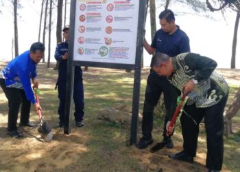 DR. AZMAN Ibrahim (kanan) memasang papan tanda amalan baik di kawasan pendaratan penyu di Pantai Teluk Mak Nik, Kemaman, Terengganu, hari ini. - FOTO/NIK NUR IZZATUL HAZWANI NIK ADNAN