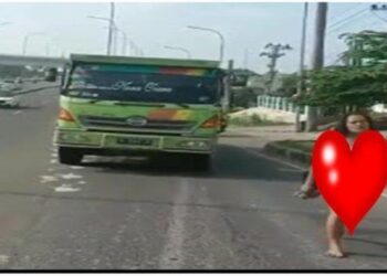 TANGKAP layar video menunjukkan seorang wanita separuh bogel berjalan di tepi jalan di Sukarai, Palembang, Indonesia. - AGENSI