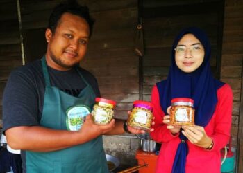 Shahasri Misngaini dan Nurhidayah Shamsuddin menunjukkan produk peria goreng di rumah mereka di Kampung Perepat Kapar Selangor. - Utusan/ ABDUL RAZAK IDRIS