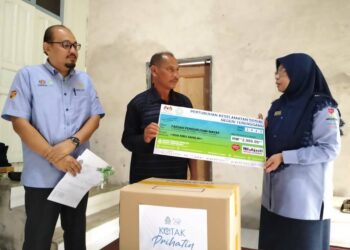 FARIHAH Che Husin menyampaikan replika cek faedah caruman Perkeso kepada waris Allahyarham Zaidah Yusof di Kampung Kelulut, Marang, hari ini. - UTUSAN/KAMALIZA KAMARUDDIN