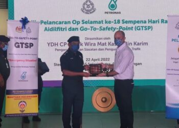 MAT Kasim Karim (kiri) menyerahkan plug Program GSTP di Stesen Petronas Solaris Putra kepada wakil Petronas.