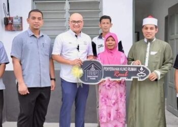 NGATANI Wagiman (depan, tiga dari kanan) menerima replika kunci RRP daripada Fadzli Mohamad Kamal (tiga dari kiri) di Kampung Sungai Pasu di Raub, Pahang, semalam. - FOTO/HARIS FADILAH AHMAD