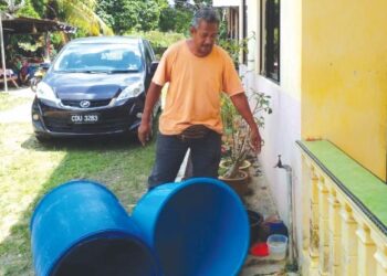 BAHARUDDIN Daud menunjukkan tong untuk menyimpan air yang sudah kering di rumahnya di Kampung Mambang Berulang, Mentakab, Temerloh, Pahang. – FOTO/SALEHUDIN MAT RASAD