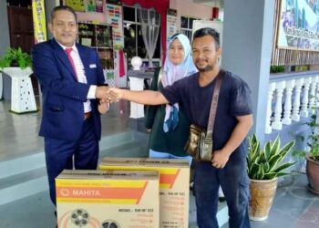 MUHAMAD ROZI Said (kanan) menyampaikan dua set kipas kepada Jamaludin Baharun di Sekolah Kebangsaan Jerantut Jaya di Jerantut, Pahang. - UTUSAN/HARIS FADILAH AHMAD