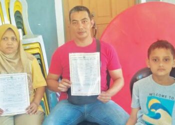 MAZLAN Mahat (tengah) dan isterinya, Novi Astuti Nasution bersama anak mereka, Khalis Nabhan Althaer (kanan) yang tiada MyKid di Felda Kota Gelanggi Dua di Jerantut, Pahang. – FOTO/HARIS FADILAH AHMAD