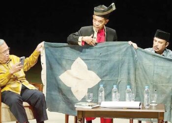 ARIPIN Said (tengah) menunjukkan Bendera Tok Jebek dalam forum berkaitan ketokohan pahlawan Mat Kilau di Kuala Lumpur, baru-baru ini.