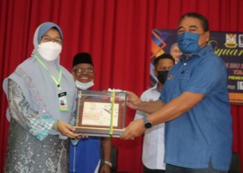 ISMAIL Mohamed Said (kanan) menerima cenderamata daripada Pengetua SMK Jengka 18, Zaitun Ismail pada majlis Mesyuarat Agung PIBG Ke-41 sekolah itu di Kuala Krau, Pahang. - FOTO/SALEHUDIN MAT RASAD