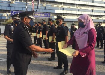RAMLI Mohamed Yoosuf (kiri) menyampaikan sijil penghargaan kepada anggota polis termasuk kakitangan penjawat awam yang berkhidmat di IPK Pahang pada majlis perhimpunan bulanan bagi Januari 2022 di Kuantan, Pahang. - FOTO/DIANA SURYA ABD. WAHAB
