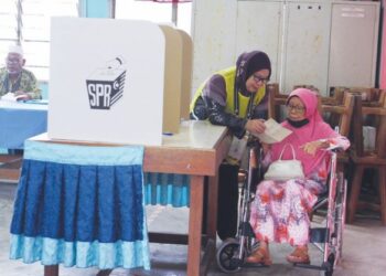 SEORANG petugas SPR membantu Zauyah Sulaiman memangkah kertas undi di Pusat Pengundian SK Pontian di Rompin, Pahang, semalam.