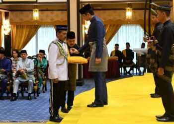 TENGKU Hassanal Ibrahim Alam Shah berkenaan menyampaikan darjah kebesaran SSAP yang membawa gelaran Datuk Seri kepada Mohd. Yusri Hassan Basri di Balairung Seri Istana Abu Bakar di Pekan, Pahang.