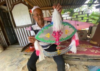 ARIFIN Hamzah menunjukkan wau bulan miliknya yang dijual pada harga RM50 bergantung kepada saiz di Kampung Belukar, Damak di Jerantut, Pahang. - UTUSAN/NORHAFIZAN ZULKIFLI