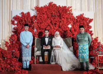 AHMAD ZAHID Hamidi (kiri) bergambar bersama pengantin Muhammad Bukhari Mohd. Isa dan Nur Nishaq Izzaty Md. Asri ketika menghadiri majlis resepsi anak kepada Md. Asri Ab. Rahim (kanan) bertempat di sebuah hotel di Ayer Keroh, Melaka. - UTUSAN/SYAFEEQ AHMAD