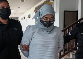 TERTUDUH diiring keluar anggota polis selepas mengaku tidak bersalah di Mahkamah Majistret, Ayer Keroh, Melaka atas pertuduhan mengugut untuk menikam sampai mati bekas kekasih. - UTUSAN/SYAFEEQ AHMAD