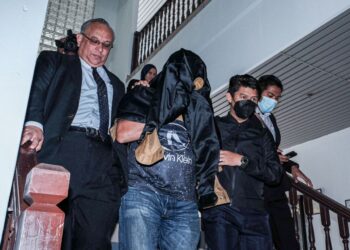 TERTUDUH diiring keluar anggota polis selepas mengaku tidak bersalah di Mahkamah Sesyen, Ayer Keroh, Melaka atas pertuduhan memberi keterangan palsu kepada mahkamah membabitkan kes rasuah seorang anggota polis. - UTUSAN/SYAFEEQ AHMAD