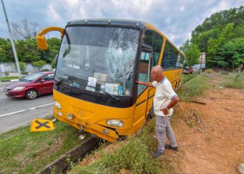 SEBUAH bas sekolah terbabas di Lebuh AMJ berhampiran Taman Malinja, Melaka. - UTUSAN/SYAFEEQ AHMAD