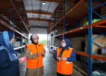 AIMAN Athirah Sabu (tengah) diberi taklimat  mengenai stok bekalan makanan dan keperluan asas mangsa banjir  di Depoh Simpanan Keperluan Bencana JKM Pulau Kerengga, Marang, Terengganu, hari ini.- UTUSAN/KAMALIZA KAMARUDDIN