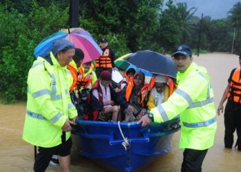 ANGGOTA polis membantu memindahkan penduduk yang terlibat banjir di Besut, Terengganu, hari ini.