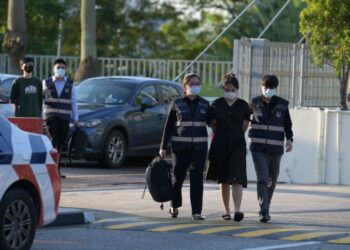SIRIWA PANSUK (depan) dan Pi Jiapeng ditahan dan diserahkan kepada Polis Singapura, kelmarin.-CNA
