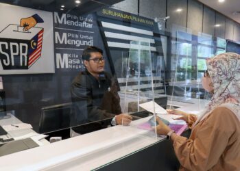 Seorang petugas SPR membantu orang awam menyemak daftar pemilih di Putrajaya, semalam. – UTUSAN/FAISOL MUSTAFA