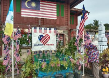 NORMALA Md. Desa atau lebih mesra disapa Cikgu Mala menggunakan 300 helai Jalur Gemilang sebagai hiasan dekorasi Hari Kemerdekaan Ke-64 di halaman rumahnya di Kampung Perlis, Balik Pulau, Pulau Pinang.