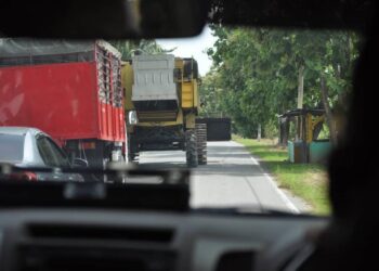 SEBUAH mesin padi yang menggunakan jalan raya yang dilihat mengundang risiko kepada pengguna jalan raya lain di sekitar kawasan Padang Melangit, Perlis.- UTUSAN