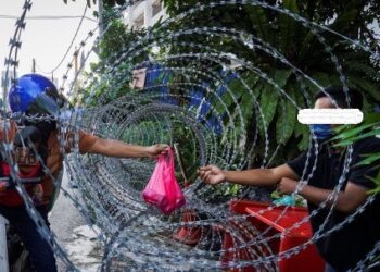 PENGHANTAR  makanan sedang membuat penghantaran kepada seorang penduduk yang terlibat dengan Perintah Kawalan Pergerakan Diperketatkan (PKPD) di Kampung Segambut Dalam, Kuala Lumpur. – UTUSAN/SHIDDIEQIIN ZON