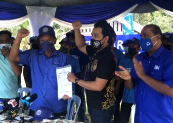 MOHD. Syahrul Ikmal Abu Othman menyerahkan borang permohonan menyertai UMNO kepada Abd. Ghani Abd. Rashid sambil disaksikan R. Vidyananthan di Kahang, Kluang, Johor. 