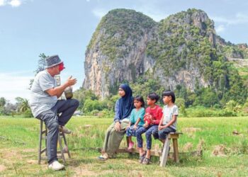 MEGAT Mohd. Noor Megat Teh (kiri) bercerita mengenai Awang Batil kepada sekumpulan kanak-kanak di Balbuk Haus, Chuping, Perlis. - UTUSAN/IZLIZAN OTHMAN