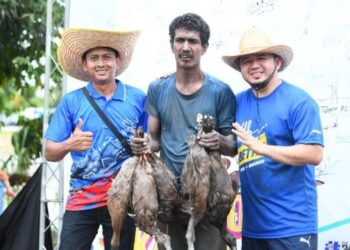 FATHUL Bari Mat Jahya (kanan) bergambar bersama peserta aktiviti menangkap itik sempena Karnival Keleboq Kangaq di kawasan sawah bersebelahan klinik desa, Behor Lateh, Kangar, Perlis, hari ini. - FOTO/IZLIZAN OTHMAN