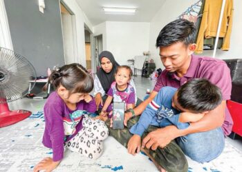 MIKAIL Rifqi Nor Radzuan bersama adik-adiknya menunjukkan gambar ibunya, Mira Azira Mohamad, 33, yang meninggal dunia di pagi Aidilfitri akibat kemalangan ketika ditemui di rumah ibu saudaranya di Pangsapuri Seri Sena, Kampung Bakau, Kangar, Perlis.- UTUSAN/NAZLINA NADZARI