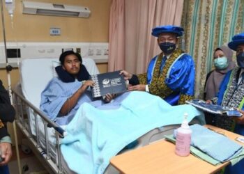 ZALIMAN Sauli (tiga dari kanan) menyerahkan skrol diploma kepada Izzat Aiman Zahari (empat dari kanan) yang tidak dapat mengikuti majlis pengurniaan skrol diploma selepas terlibat dalam kemalangan jalan raya pada 25 November lalu. - FOTO/IZLIZAN OTHMAN