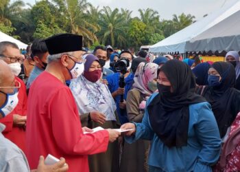 ISMAIL SABRI Yaakob (baju Melayu merah) menyampaikan sumbangan sempena program Semarak Ramadan di Dewan Semai Bakti Felda Purun di Bera, Pahang. - UTUSAN/SALEHUDIN MAT RASAD
