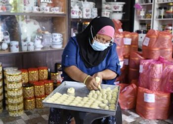 NOR  Jan Bee Omar menyiapkan tempahan kuih raya yang diterima daripada pelanggan di sebuah bengkel khas di Bagan Ajam, Pulau Pinang.